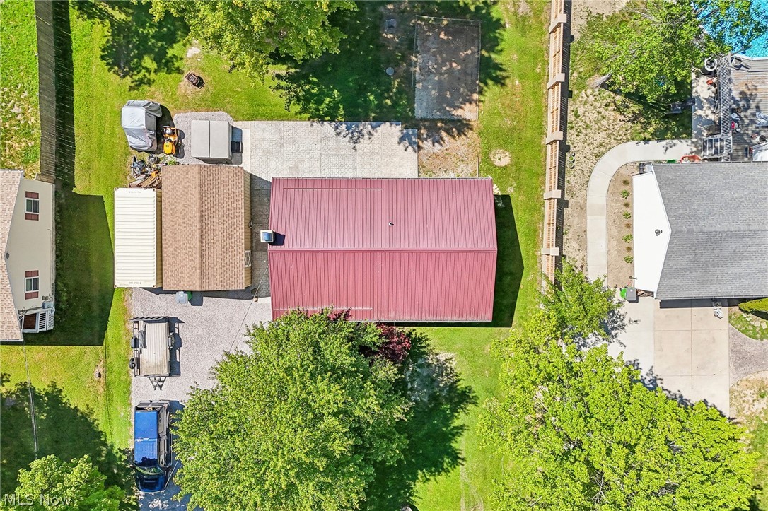 2960 Rome Rock Creek Road Rock Creek, OH 44084 - Photo 48 of 49 Overhead property view featuring a red metal roof building, a brown shingled roof structure, and extensive concrete paving