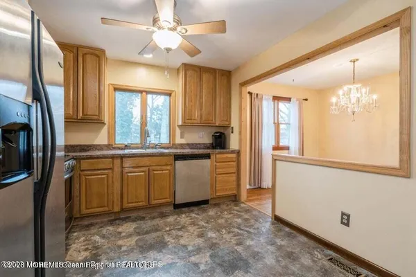 a kitchen with granite countertop a refrigerator a sink a stove and island