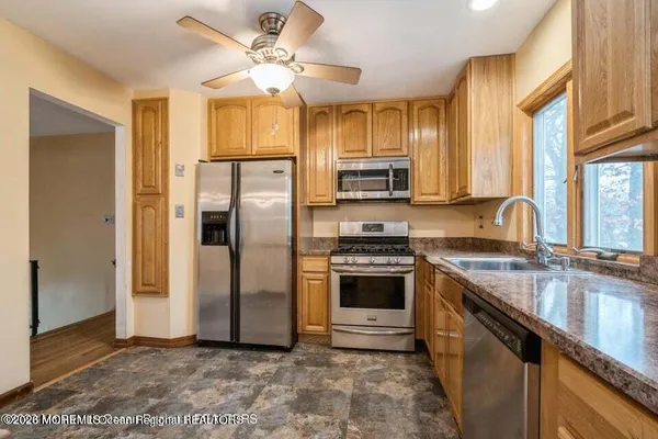 a kitchen with stainless steel appliances granite countertop a stove a refrigerator a sink a stove and island