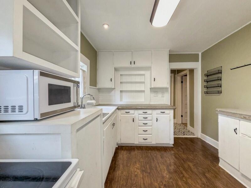 383 North Booker Street Crestview, FL 32536 - Photo 12 of 36 a kitchen with stainless steel appliances cabinets a stove and a wooden floors