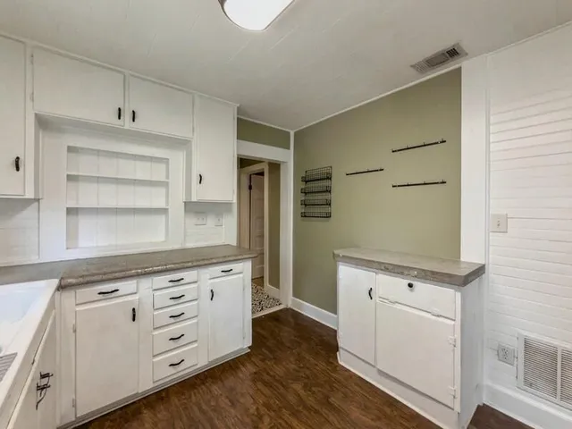 a kitchen with white cabinets and appliances