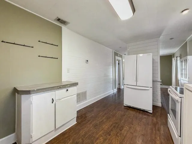 a kitchen with granite countertop white cabinets and white appliances