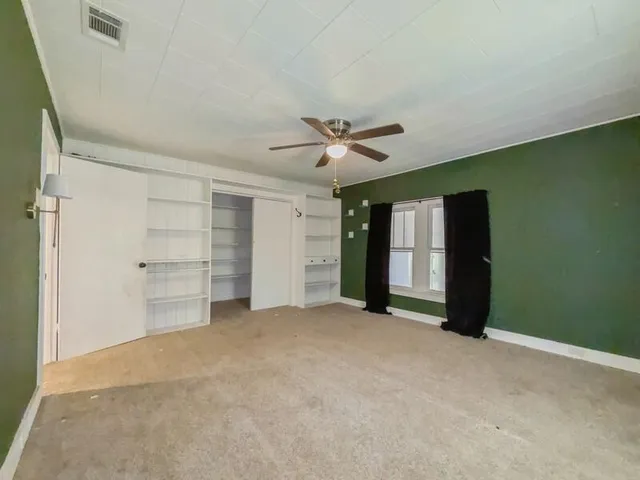 a view of a room with cabinet and a ceiling fan
