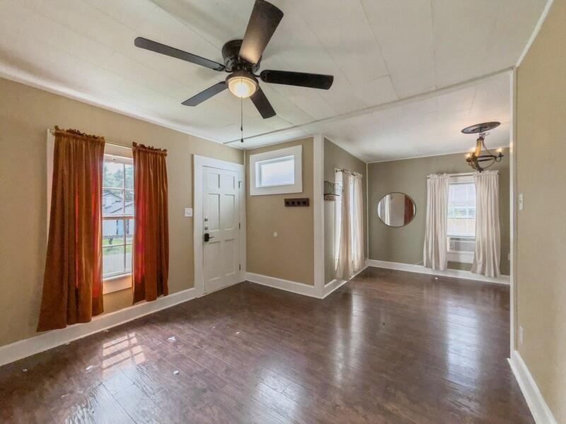 383 North Booker Street Crestview, FL 32536 - Photo 6 of 36 an empty room with wooden floor a ceiling fan and a window