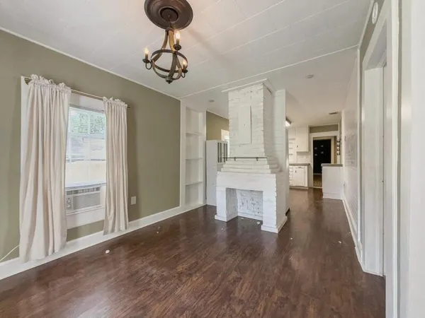 a view of a hallway with wooden floor and a kitchen