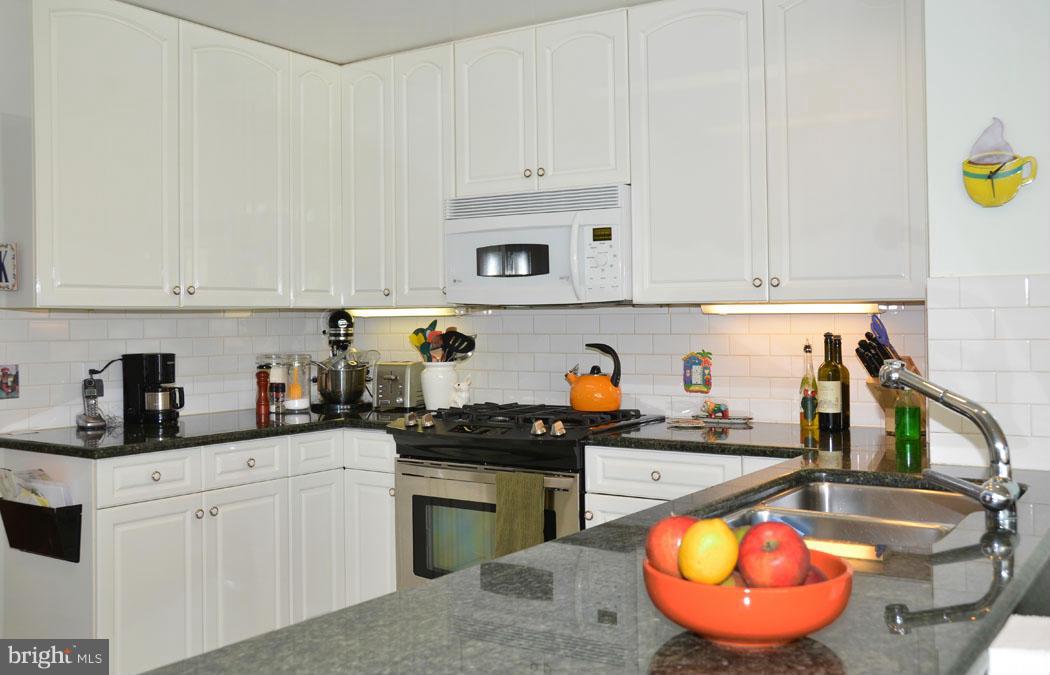 5603 Ridgefield Road Bethesda, MD 20816 - Photo 18 of 30 a kitchen with stainless steel appliances granite countertop a sink dishwasher and cabinets with wooden floor