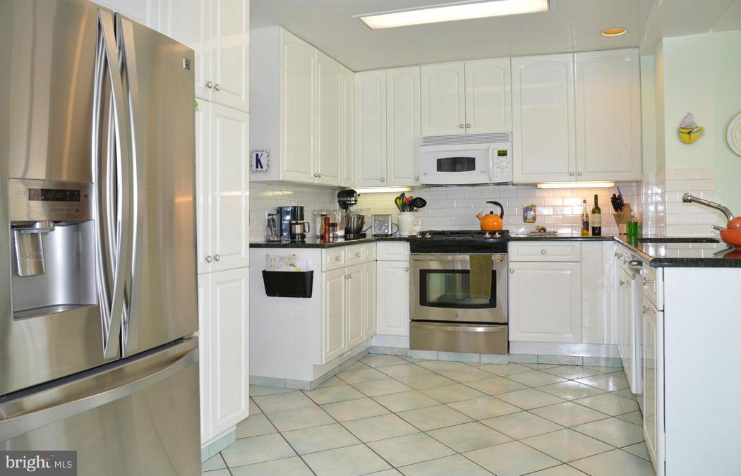 5603 Ridgefield Road Bethesda, MD 20816 - Photo 19 of 30 a kitchen with stainless steel appliances a refrigerator sink and cabinets