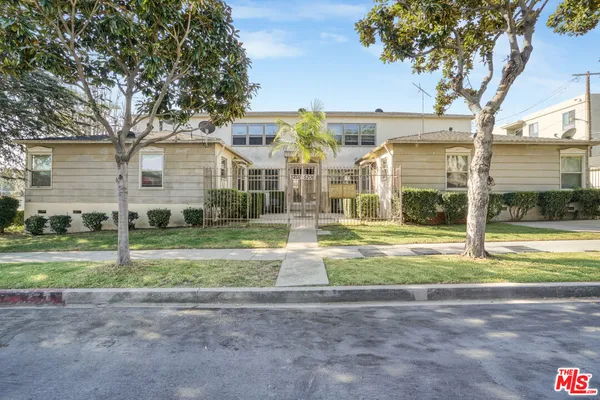 a view of a house with a big yard and palm trees