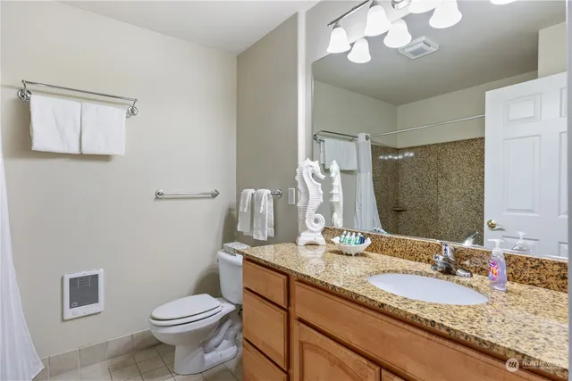 a bathroom with a granite countertop sink a toilet and a mirror