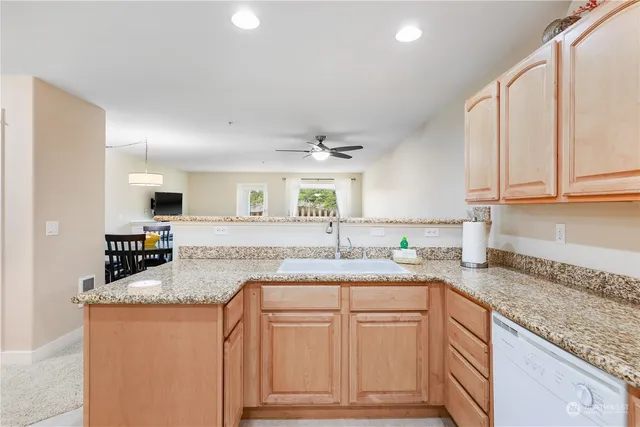a kitchen with granite countertop a sink a stove and cabinets