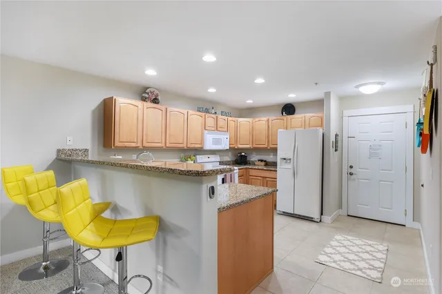 a kitchen with stainless steel appliances granite countertop a refrigerator and a sink
