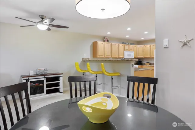 a kitchen with stainless steel appliances a dining table chairs and a chandelier