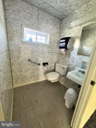 a bathroom with a toilet sink and mirror