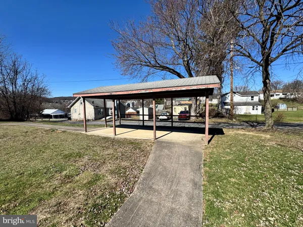 a view of a house with backyard and a tree