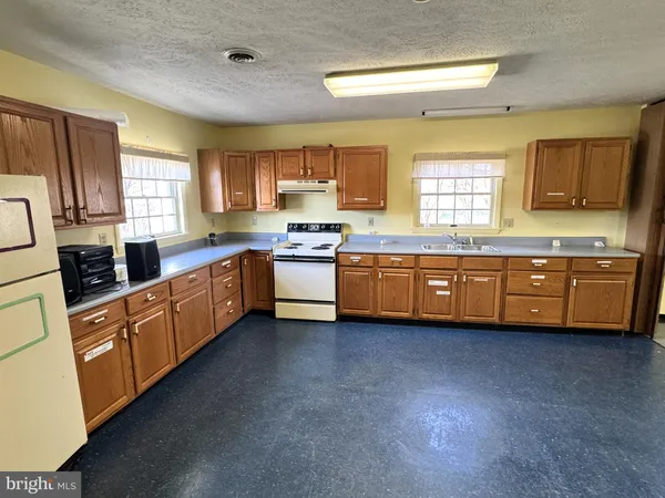 a kitchen with stainless steel appliances a sink window and cabinets