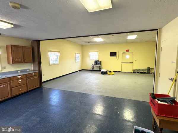 a view of an empty room and a kitchen