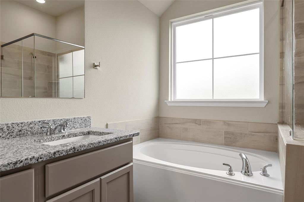 3205 Dottavio Road Lorena, TX 76655 - Photo 19 of 33 Bathroom featuring a white soaking tub with polished chrome fixtures, a large window, and light-toned wall tile