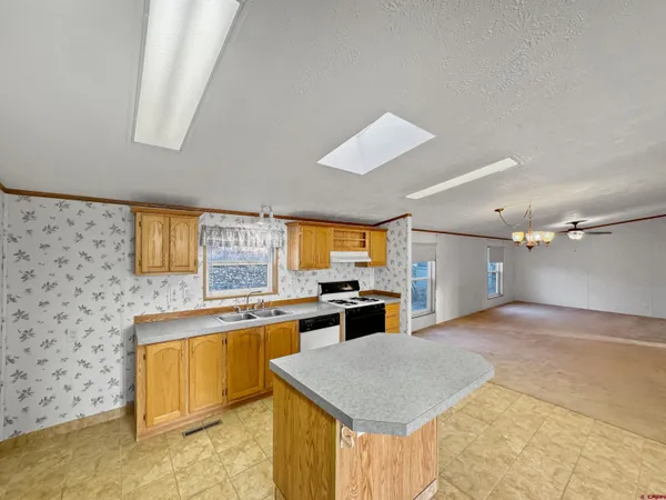 an empty room with windows and refrigerator