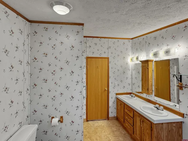 a view of a hallway with wooden floor and bathroom