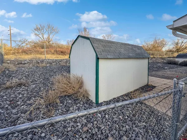 a view of a dry yard with wooden fence