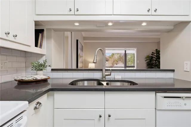 a kitchen with granite countertop a stove a sink and a microwave