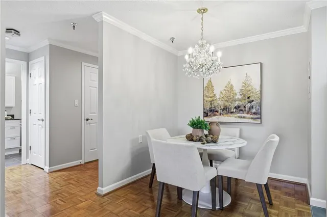 a view of a dining room with furniture a chandelier and wooden floor