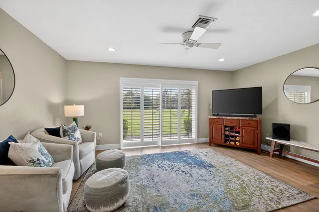 a living room with furniture a flat screen tv and a large window