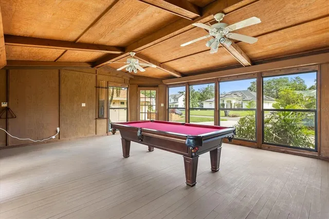 a room with pool table and windows