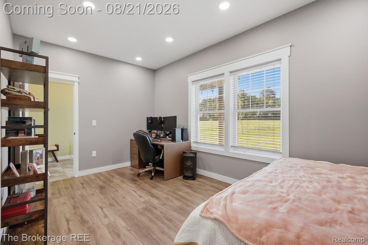 9161 East Coldwater Road Davison, MI 48423 - Photo 19 of 52 Spacious bedroom with wood-finish flooring, recessed ceiling lighting, and large multi-pane windows with plantation shutters overlooking outdoor grounds