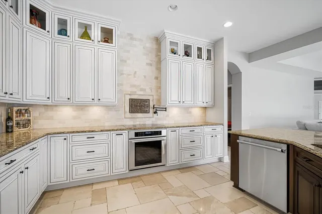 a kitchen with white cabinets stainless steel appliances and sink