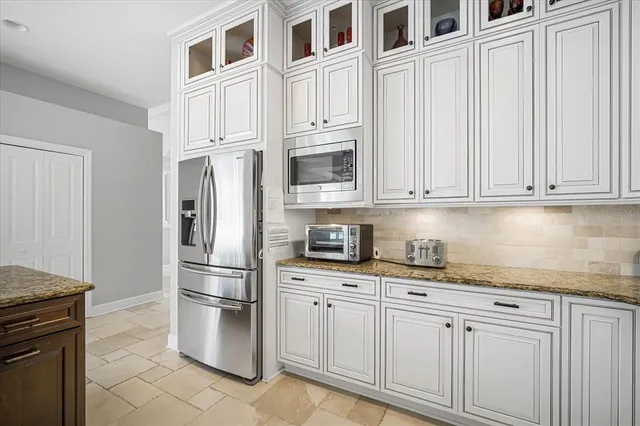 a kitchen with stainless steel appliances granite countertop a refrigerator a stove and a sink