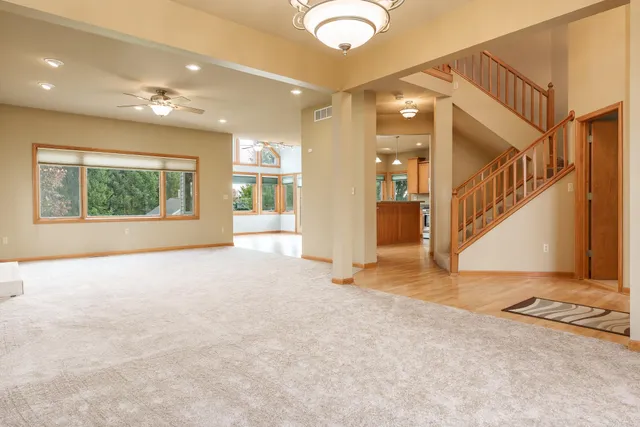 a kitchen with stainless steel appliances granite countertop a refrigerator a sink dishwasher a stove top oven a large island with wooden floor and cabinets