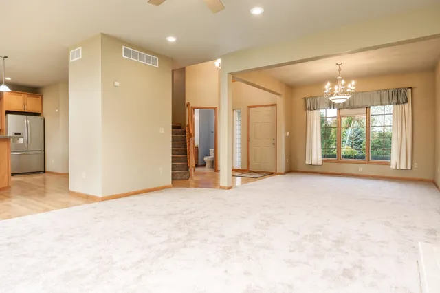 a kitchen with kitchen island a counter top space appliances and a view of living room