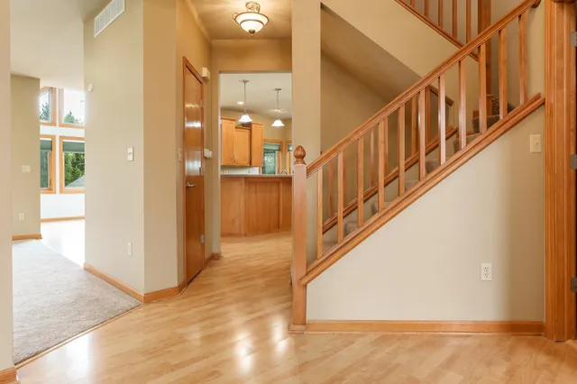 a view of an empty room with wooden floor and a fireplace