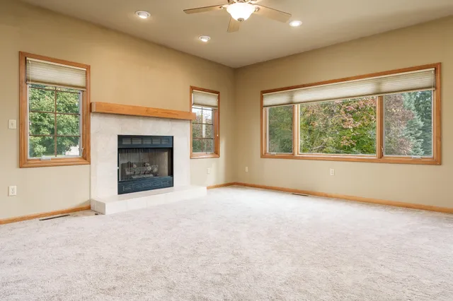 a view of an empty room with a fireplace and a window