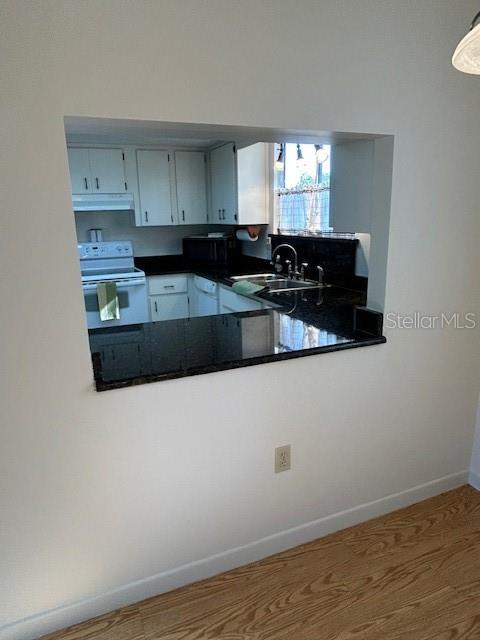 8472 Southwest 109th Street Ocala, FL 34481 - Photo 1 of 1 a kitchen with granite countertop white cabinets and black stainless steel appliances