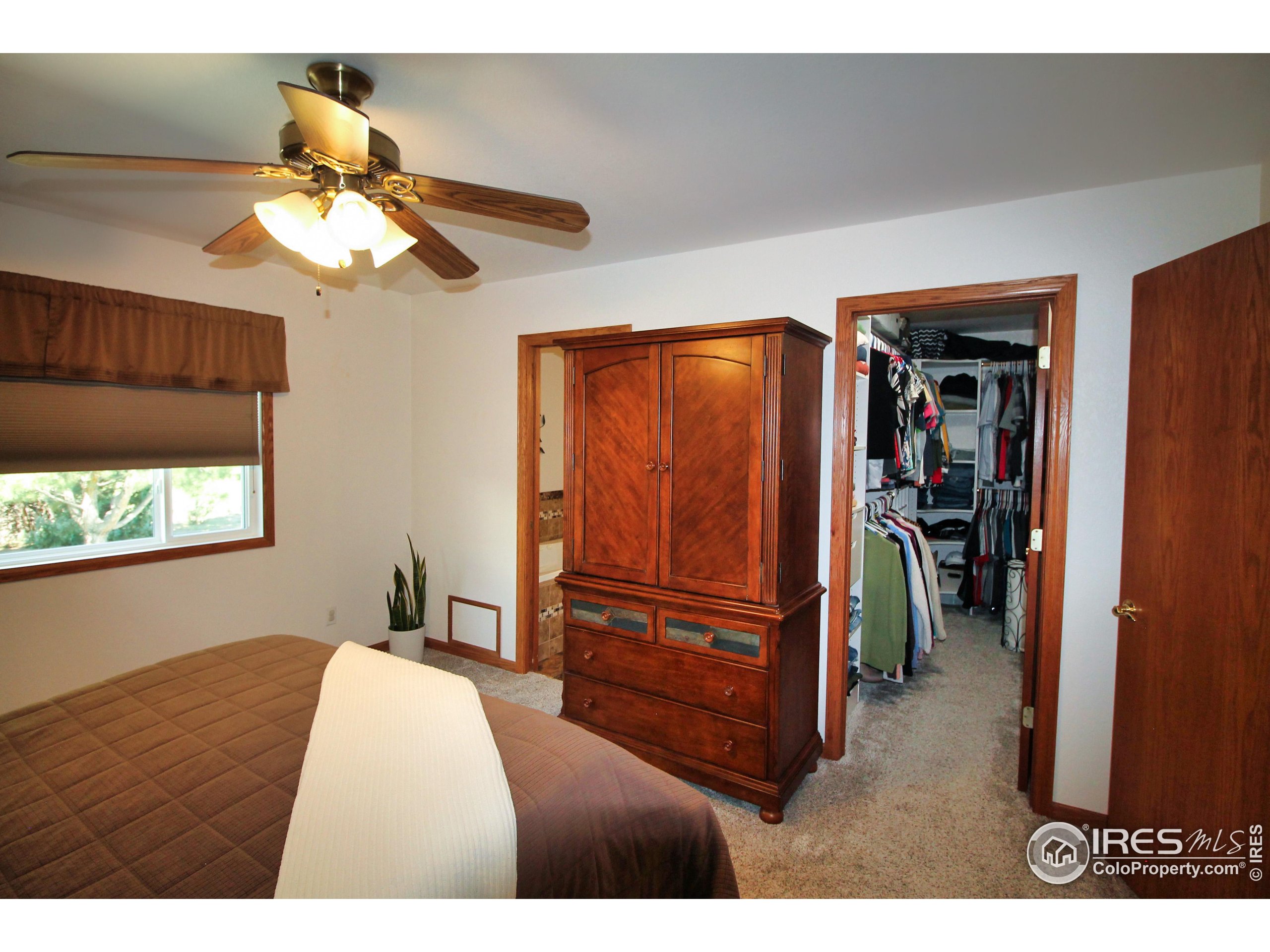 14363 Dakota Road Sterling, CO 80751 - Photo 13 of 40 a bedroom with a bed and a chandelier