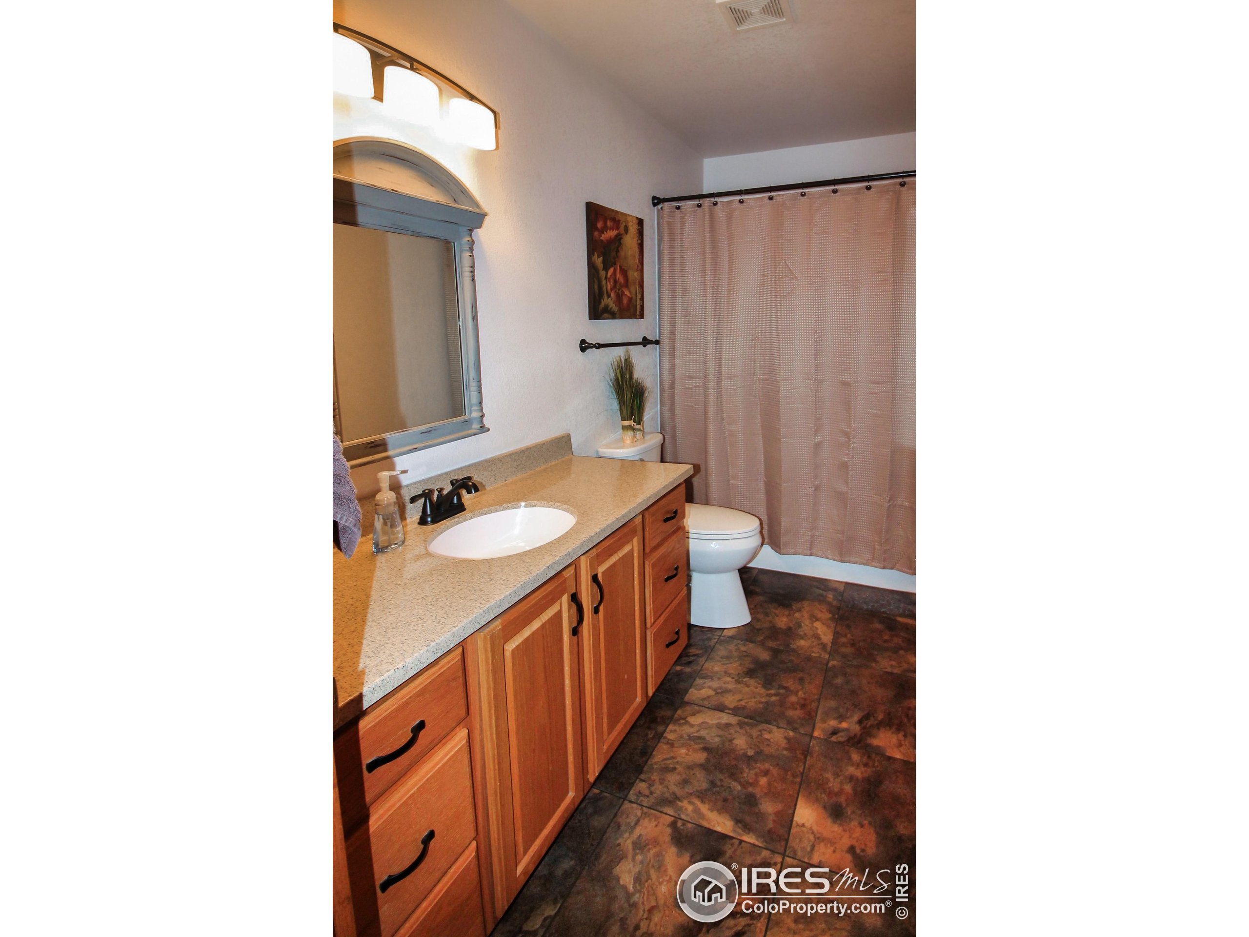 14363 Dakota Road Sterling, CO 80751 - Photo 17 of 40 a bathroom with a sink a toilet and a mirror