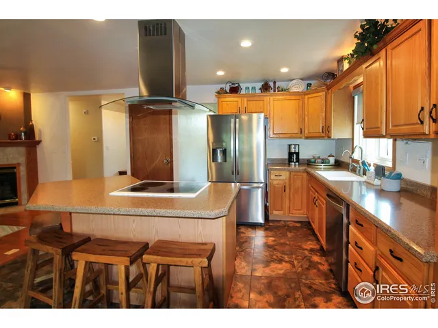 a kitchen with kitchen island granite countertop a sink cabinets and stainless steel appliances