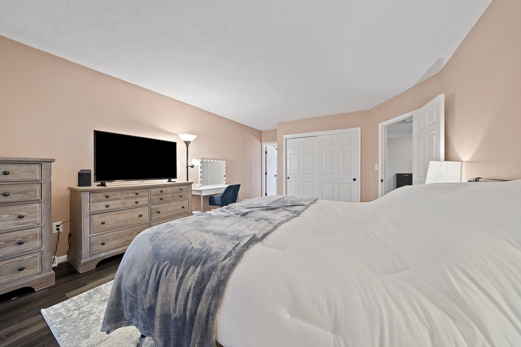 22 Union Square, Unit 22 Randolph, MA 02368 - Photo 19 of 28 a bed room with a flat screen tv and a bed