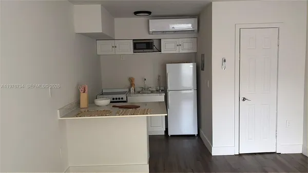 a view of a small space with wooden floor and a window