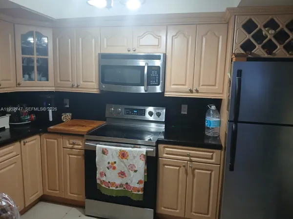 a kitchen with stainless steel appliances granite countertop a refrigerator and a stove