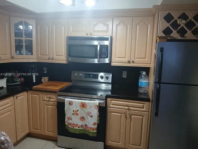 a kitchen with stainless steel appliances granite countertop a refrigerator and a stove