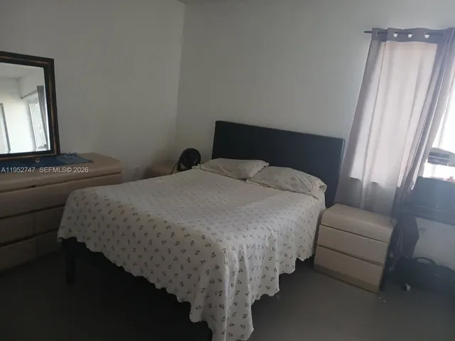 a bedroom with bed and window