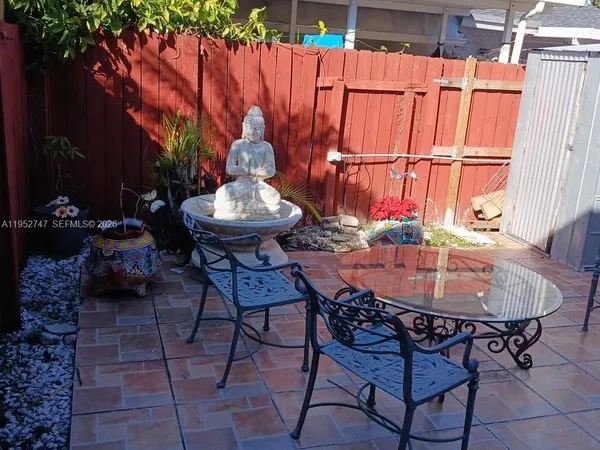 a backyard of a house with table and chairs