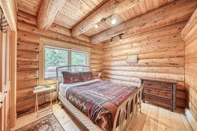 a bedroom with a bed and a dresser next to a window