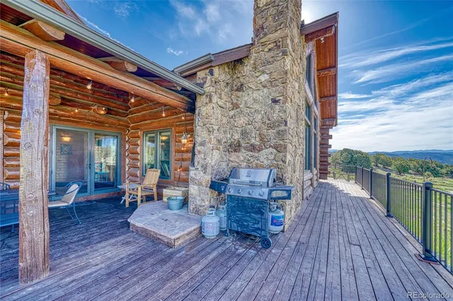 a view of a patio with table and chairs a barbeque with wooden floor and fence