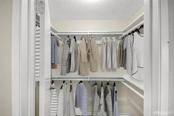 a view of walk in closet with clothes