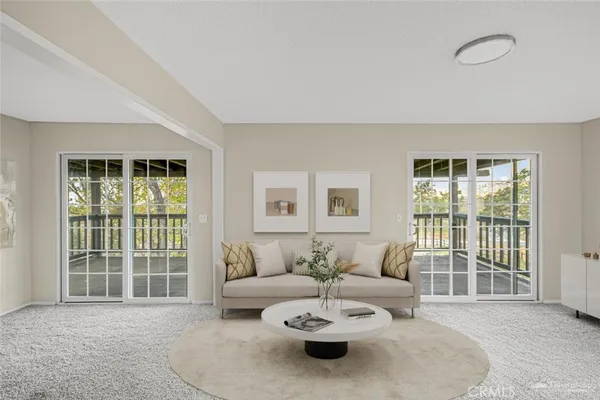 a living room with furniture and a window with garden view