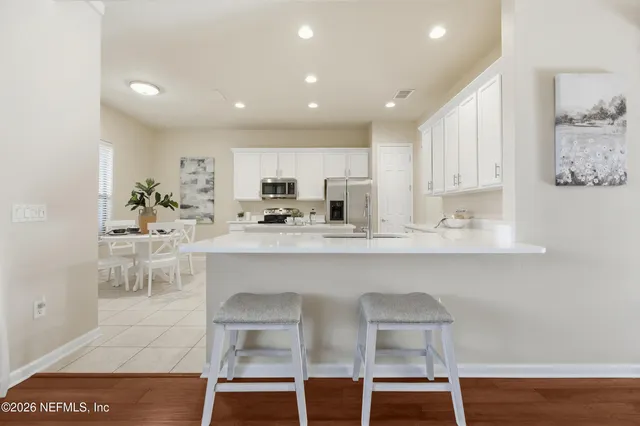 a kitchen with a sink white cabinets and stainless steel appliances